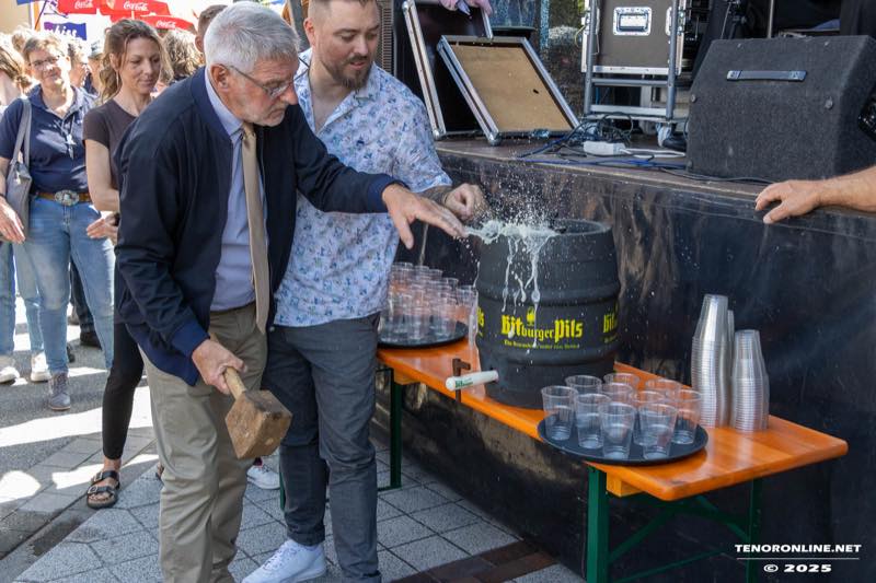 Bürgermeister Egon Völlkopf schlägt beim Fassanstich den Zapfhahn ins Bierfass, daneben stehen Becher für das Freibier bereit.