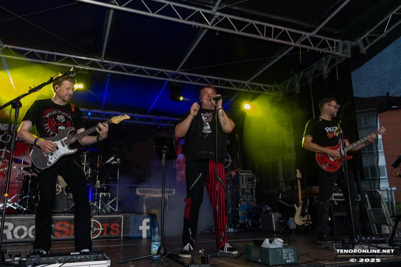 Die Band RockShots spielt am Samstagabend unter blauem und gelbem Bühnenlicht.