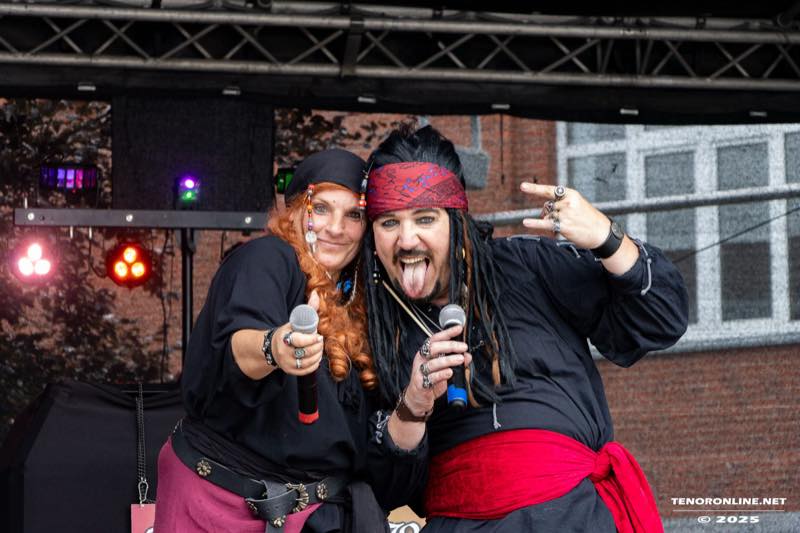 Zwei Mitglieder von Speed Beats in Piratenkostümen posieren mit Mikrofonen.